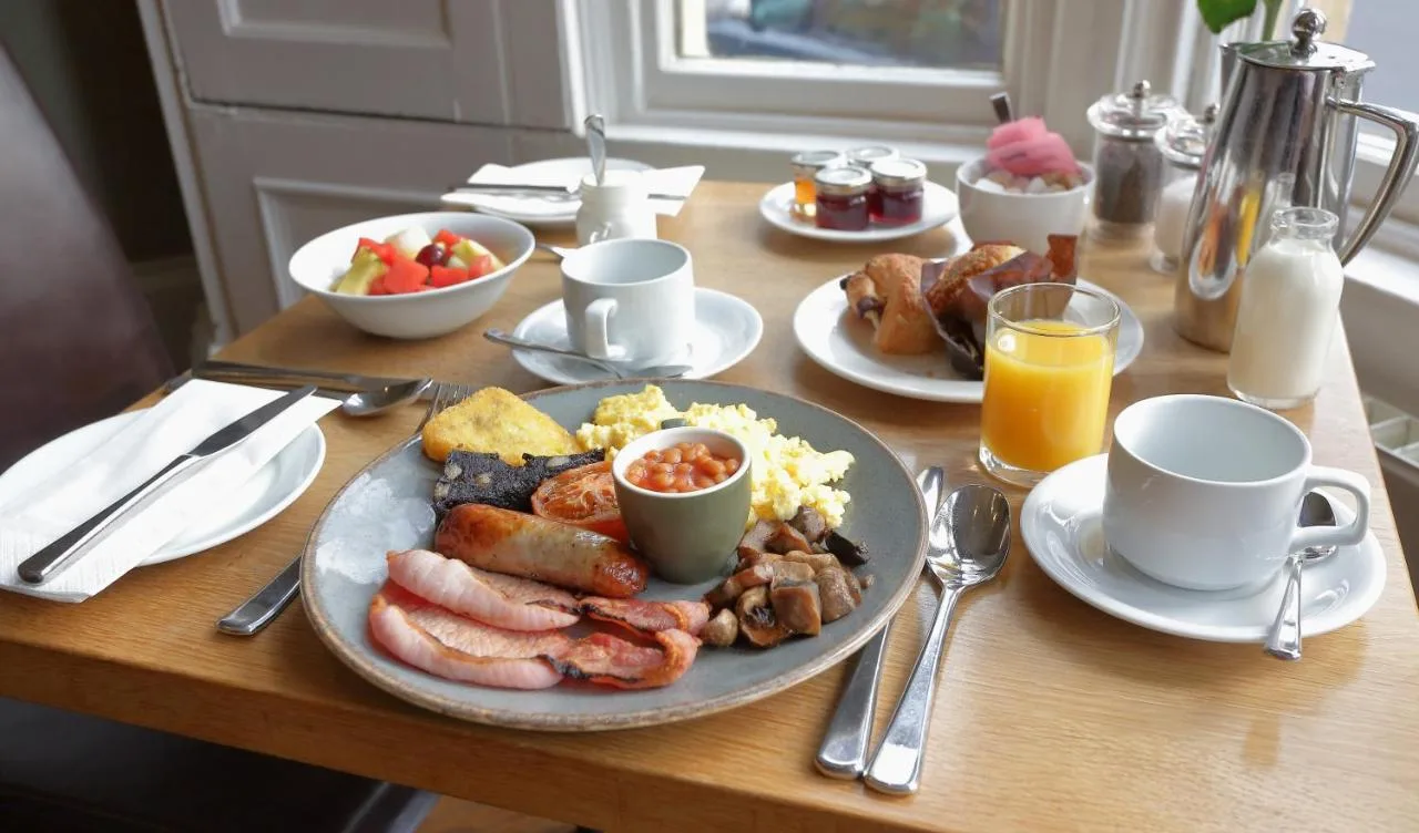 a table with a plate of breakfast food on it at The Dean Court in York